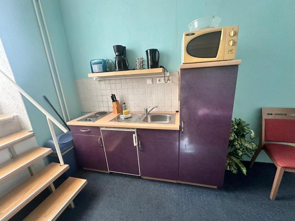 a small kitchen with a sink and a microwave at Ostsee Welle in Rostock