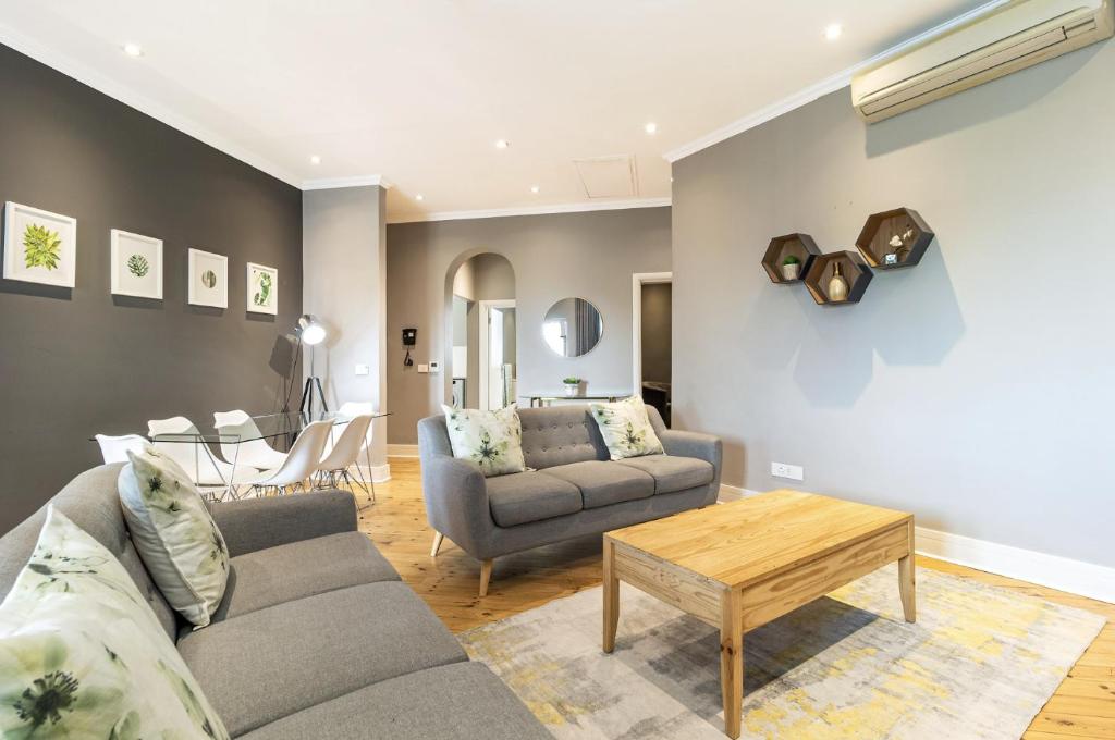 een woonkamer met een bank en een tafel bij Central Green Point Apartment in Kaapstad