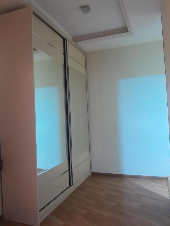 ein leeres Zimmer mit Glastüren und Holzböden in der Unterkunft Zash Apartment in Baku