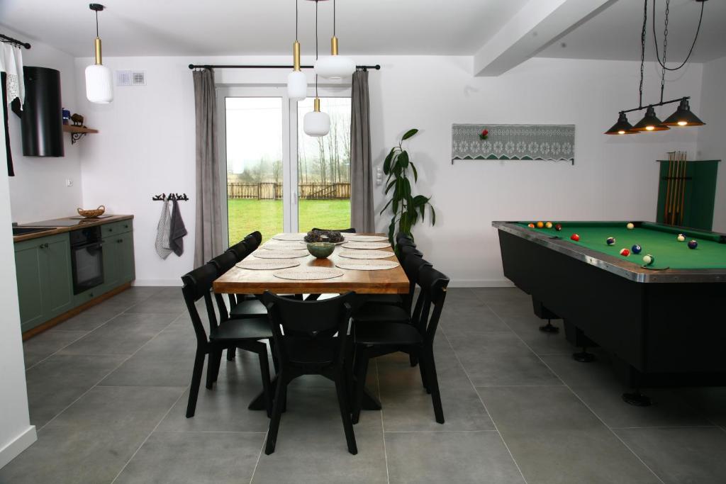 a dining room with a table and a pool table at Zacisze Teremiski in Białowieża