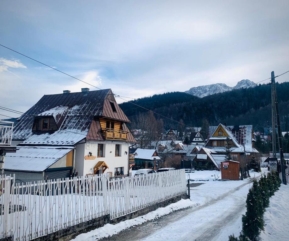 un villaggio con una staccionata bianca nella neve di Willa Długoszówka a Zakopane