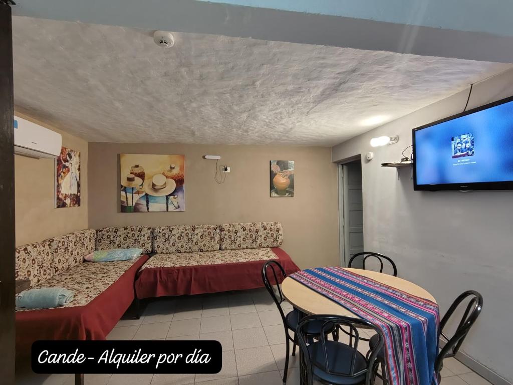 ein Zimmer mit einer Couch, einem Fernseher und einem Tisch in der Unterkunft Departamento Interno Cande in Salta