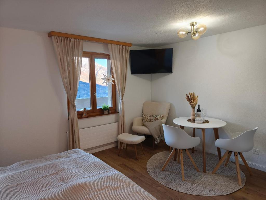 ein Schlafzimmer mit einem Bett, einem Tisch und Stühlen in der Unterkunft Apartment Panorama in Eischoll