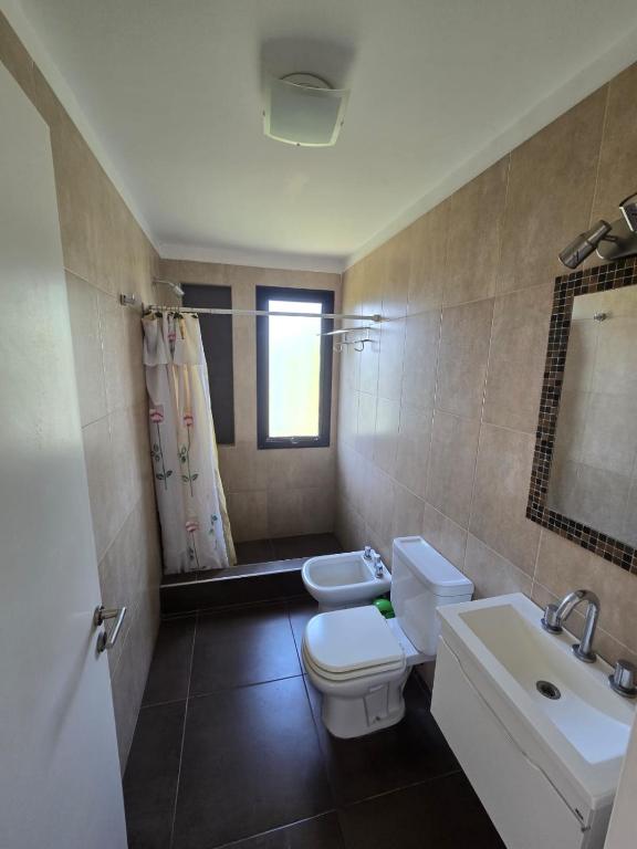 een badkamer met een toilet, een wastafel en een spiegel bij Complejo la argentina in Ostende