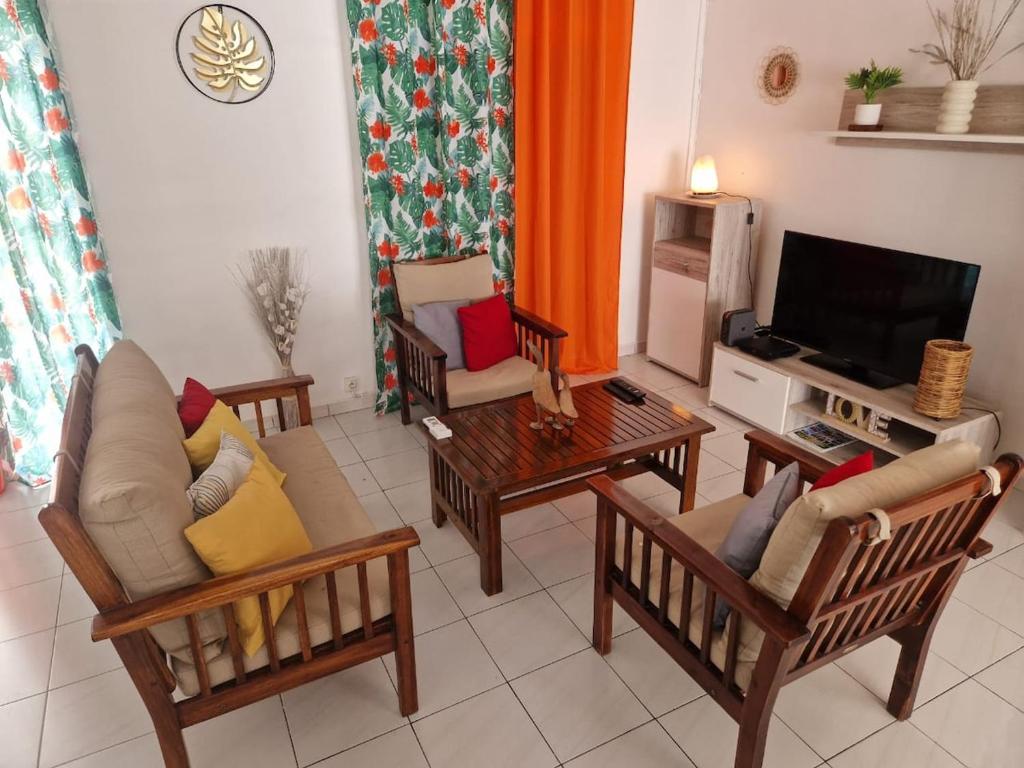 a living room with several chairs and a television at Villa Atlantis 3 chambres in Port-Louis