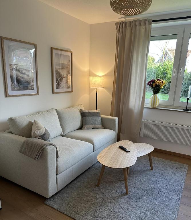 a living room with a couch and a table at Ferienwohnung Lüttje Mööv 2 an der Nordsee in Wangerland