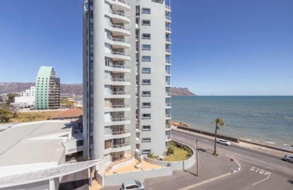 ein hohes weißes Gebäude am Meer in der Unterkunft Luxury Beach Front Apartment in Strand