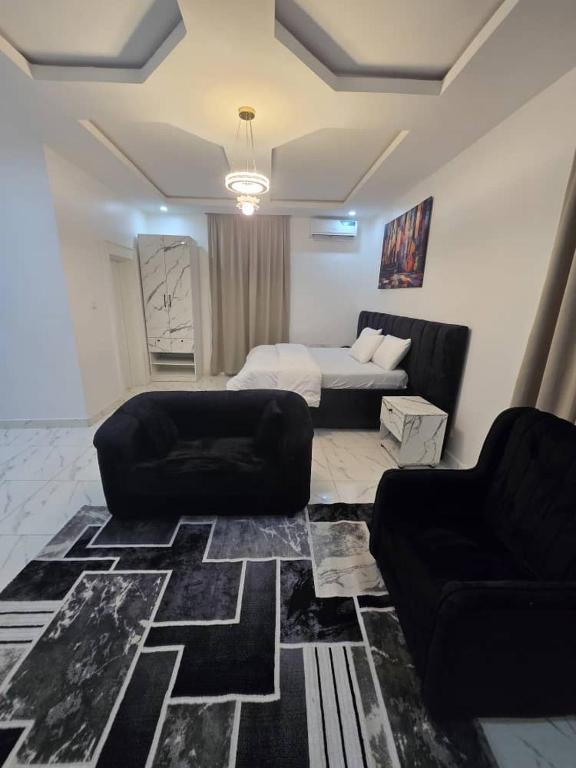 a living room with a bed and two chairs at The White Residence, Jabi, Abuja in Abuja