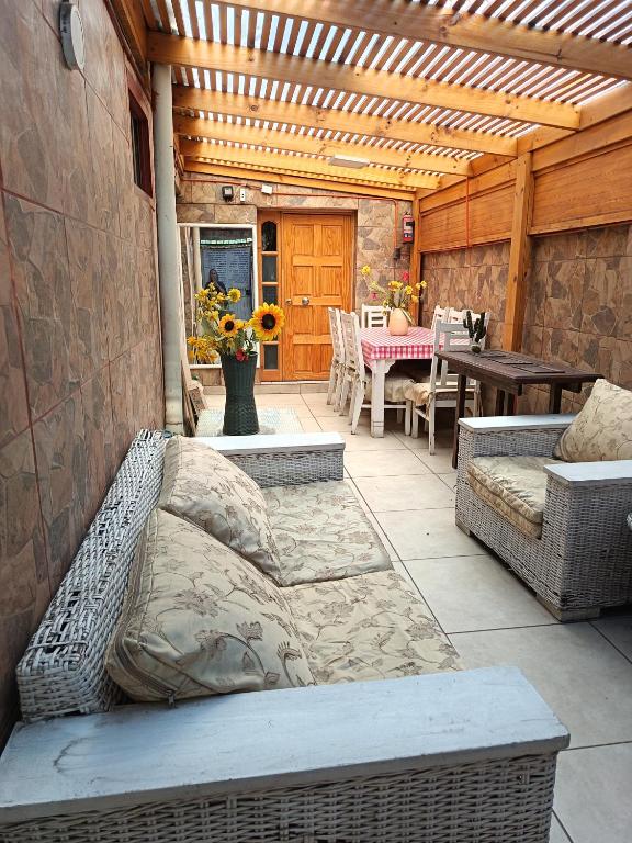 a patio with a couch and a table and chairs at Casa Hostel Javi in Santiago