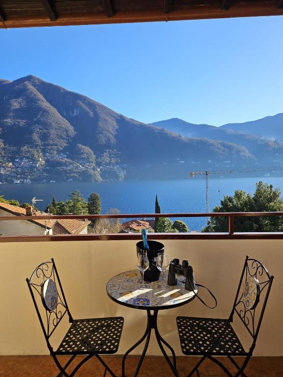 a table and two chairs on a balcony with a view at Dimora Paradise in Laglio
