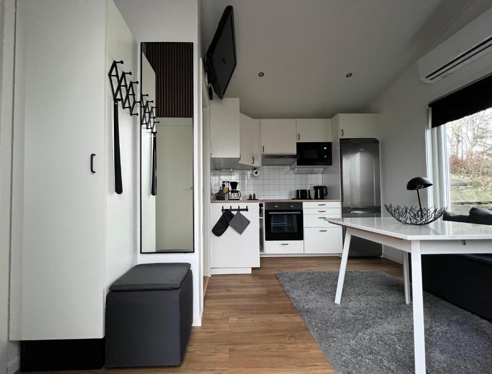 The Fäxaåsen cabin في فاربرغ: مطبخ بدولاب بيضاء وطاولة بيضاء