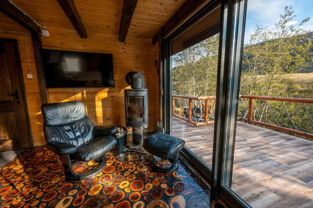 eine abgeschirmte Veranda mit einem Schaukelstuhl auf einem Deck in der Unterkunft Gorski Mir in Berane