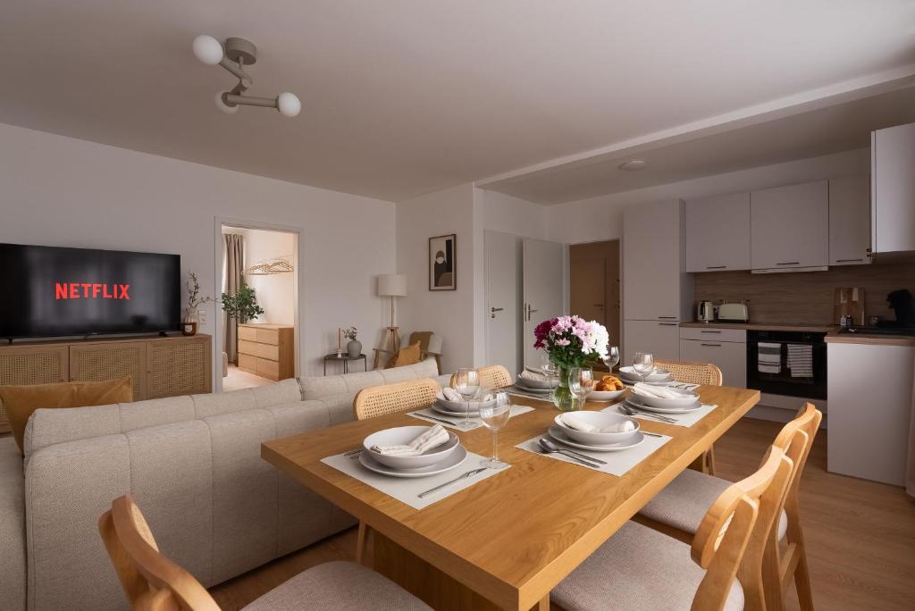 - une salle à manger et un salon avec une table en bois dans l'établissement SaLi - Design Apartments, à Trossingen