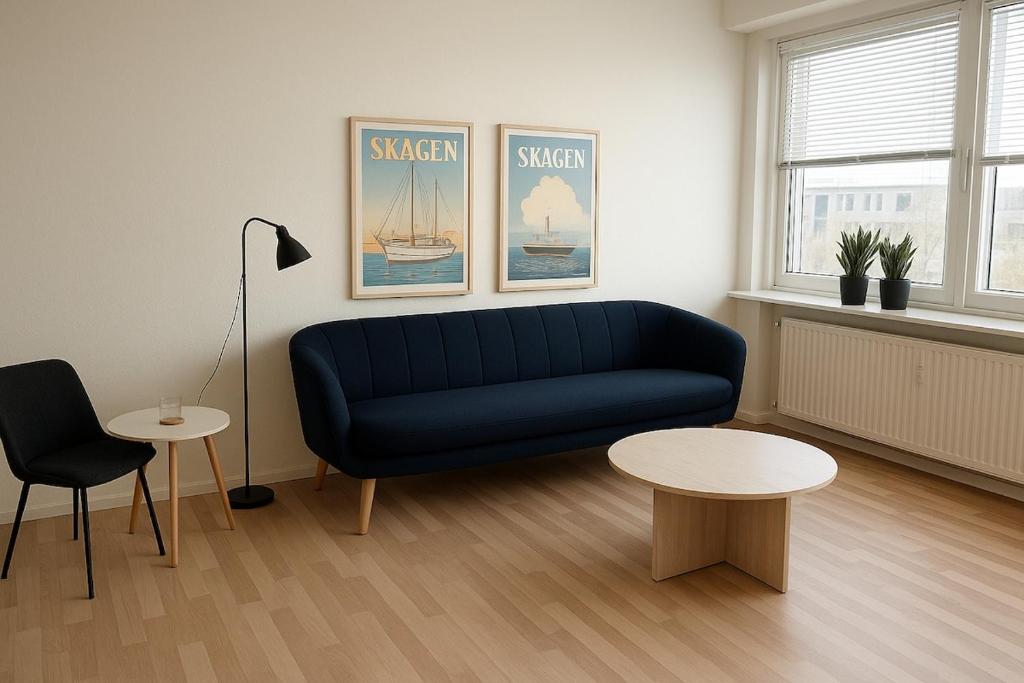 2 bedroom apartment in the heart of Randers في راندرس: غرفة معيشة مع أريكة زرقاء وطاولتين