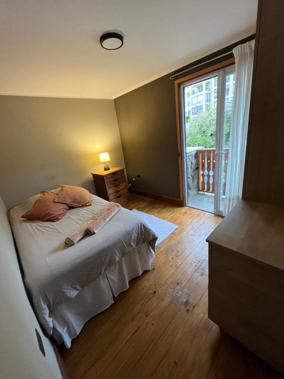 a bedroom with a bed and a large window at Tribu in Viña del Mar