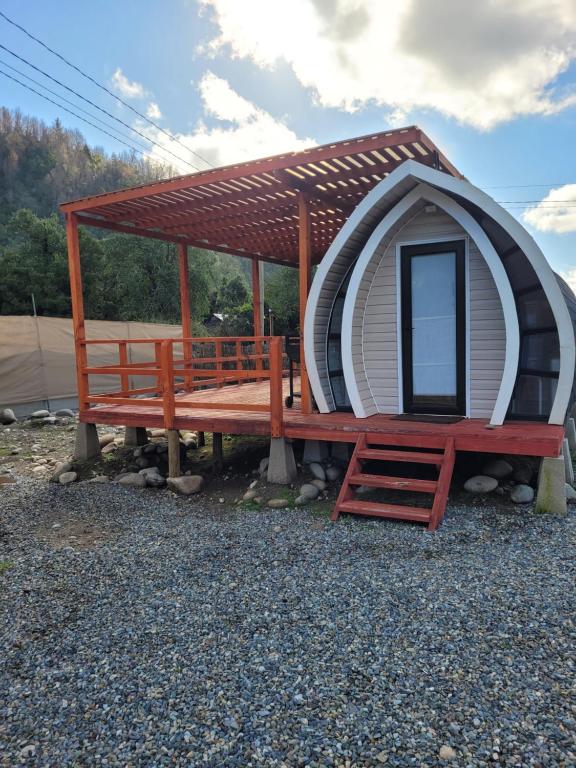 利纳雷斯Achibueno Glamping的一座带长椅和门廊的小型圆顶房屋