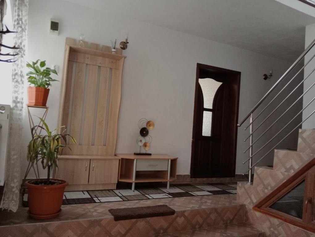 Cette chambre dispose d'un escalier, d'une table et d'une porte. dans l'établissement Cabana Bianca & Iair, à Poiana Vadului