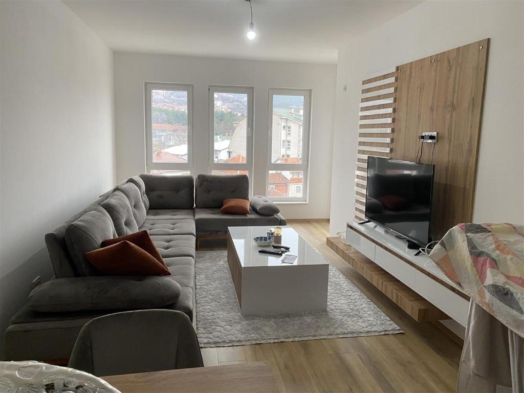 een woonkamer met een bank en een tv bij Luxury CH Apartments in Pristina