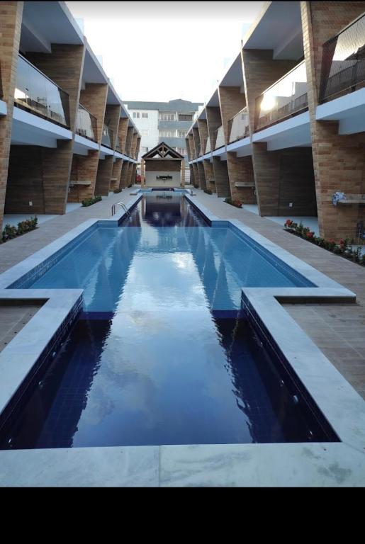 a large swimming pool inside of a building at Bangalô Camboinha triplex in Cabedelo