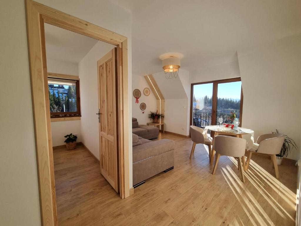 een woonkamer met een tafel en een bank en een eetkamer bij Apartament 7niebo in Gliczarów Górny