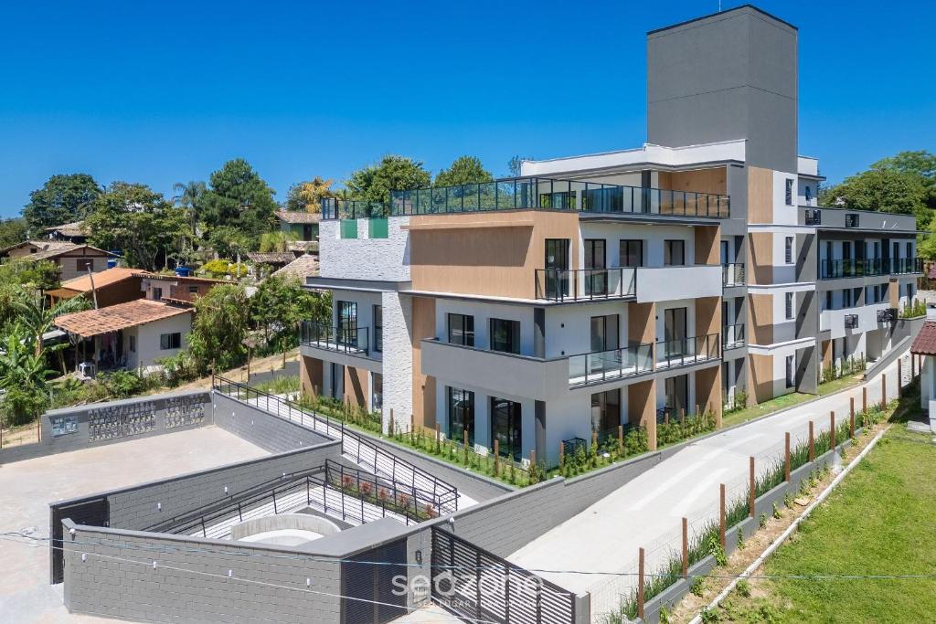 een luchtfoto van een gebouw met een zwembad bij Studios Modernos a 2km da Praia do Rosa - RSOs in Praia do Rosa