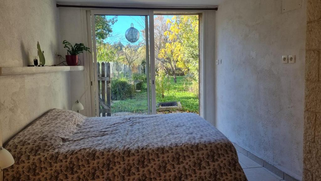 een slaapkamer met een bed en een groot raam bij La suite d'Ananda in Villefranche-de-Rouergue