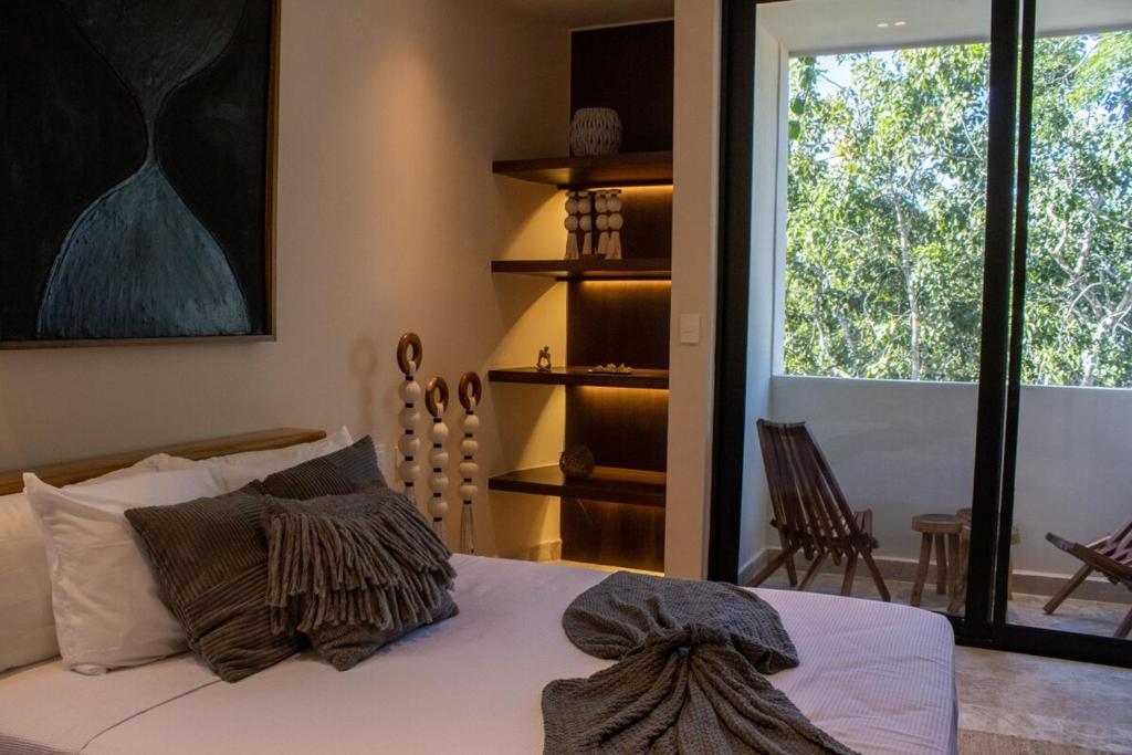 a bedroom with a bed and a window with a view at Peregrina Tulum 301C 1BR Condo in Tulum