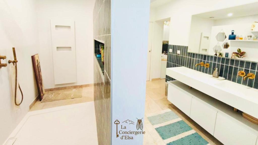 a bathroom with white cabinets and blue tiles at La Chambre du Soleil in Arles