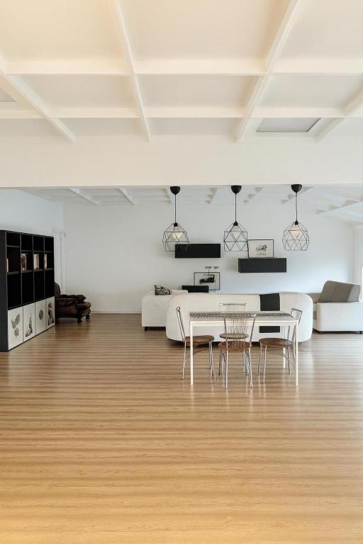 a white living room with a table and chairs at La Manovella Apartment in Caselle Torinese