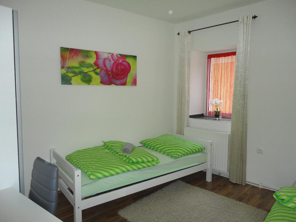a bedroom with a bed with a green comforter and a window at Rentcenter79 in Vordernberg