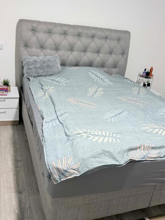 een bed met een blauw dekbed met bladeren erop bij bekaNET in Mazgit
