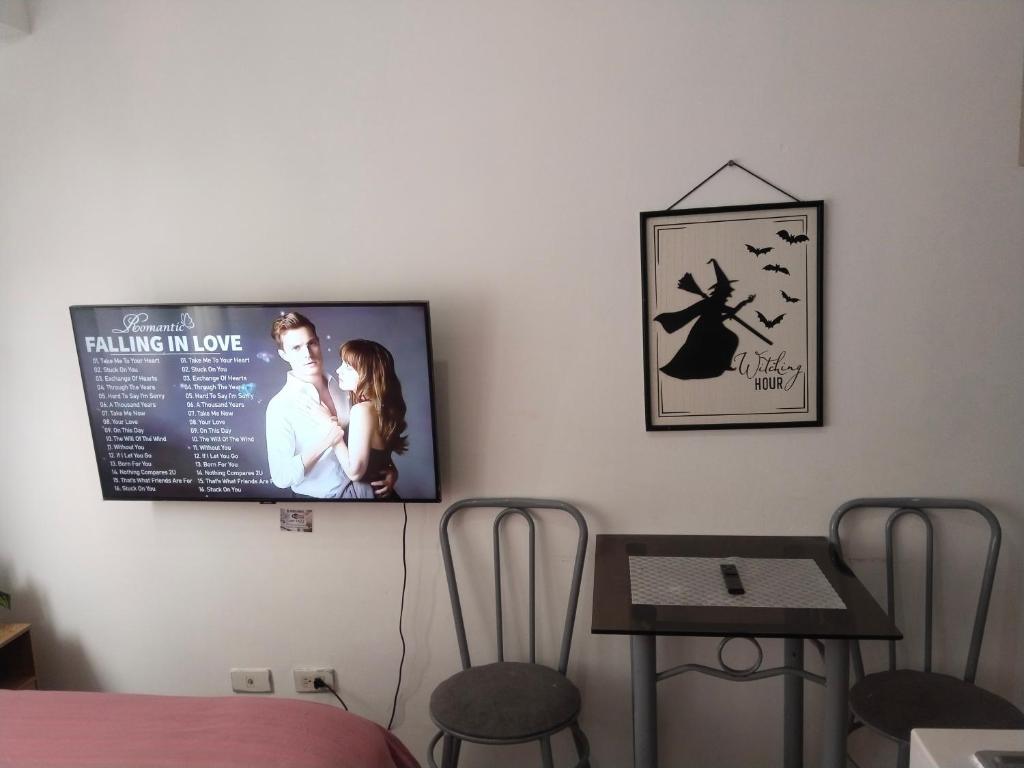 a room with a tv on the wall with a table and chairs at Nicecondotel in Manila