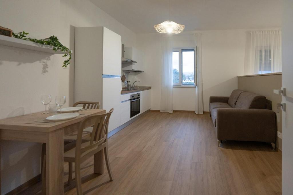 Una cocina y una sala de estar con una mesa y un sofá. en Casa di Viola - Peonia, en Latina