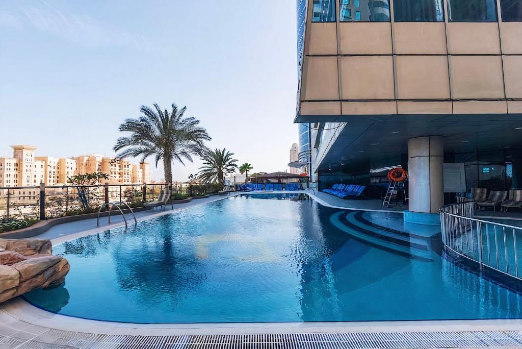 ドバイにあるDubai Marina Modern 1 Bedroom Apartment - steps to tram & Marina Walkの建物の前の大きなプール