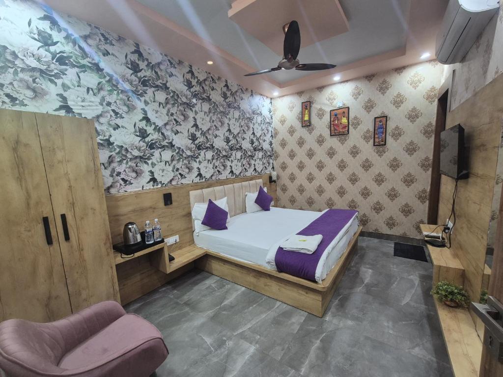 a bedroom with a bed and a chair at Hotel Devi Residency Vrindavan - Near Premanand ji Maharaj And Prem Mandir, Banke Bihari ji in Jāmb