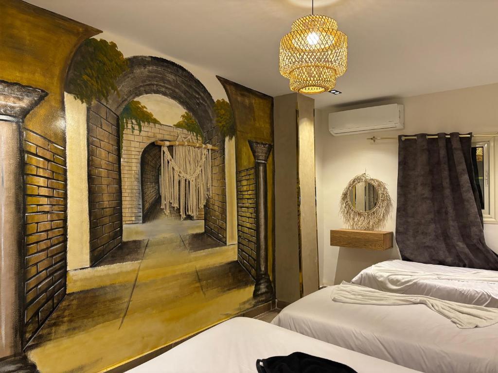 Zimmer mit 2 Betten und Wandbild in der Unterkunft 4 Pyramids INN in Kairo