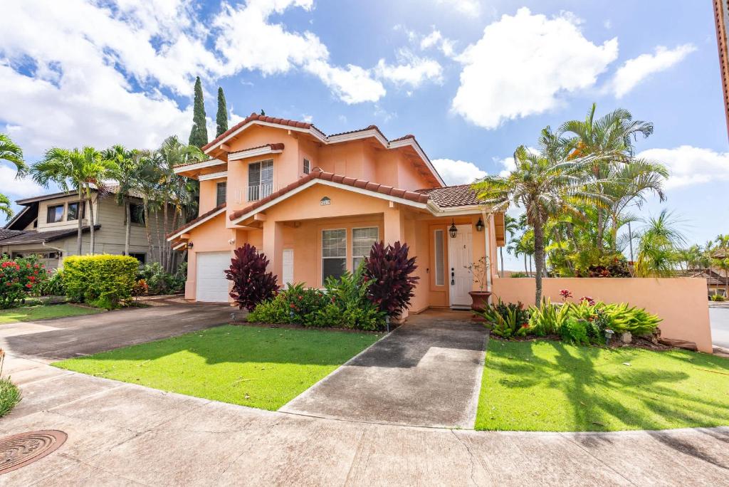 カポレイにあるMarbella Lane Posh 4BR with Spectacular Viewsのヤシの木と緑の庭のある家