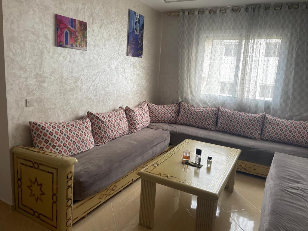 uma sala de estar com um sofá e uma mesa em Farah airport résidence em Tânger