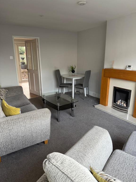 a living room with couches and a table and a fireplace at 3-Bed House Brighouse Parking Wi-Fi Near M62 in Brighouse