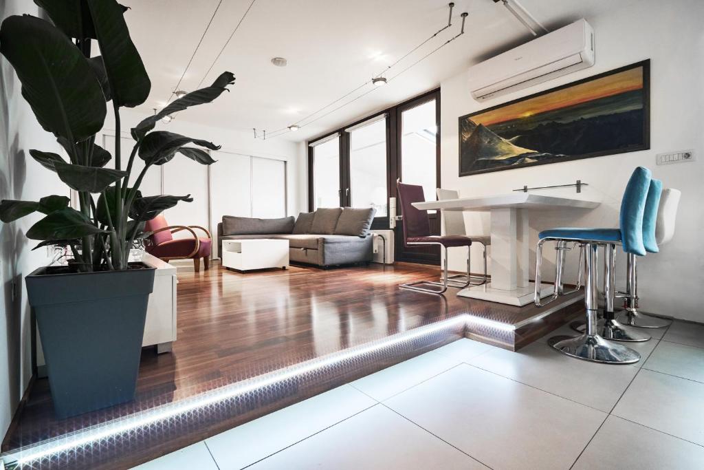 een woonkamer met een bank en een tafel bij Matic Murgle Atrium Apartment in Ljubljana