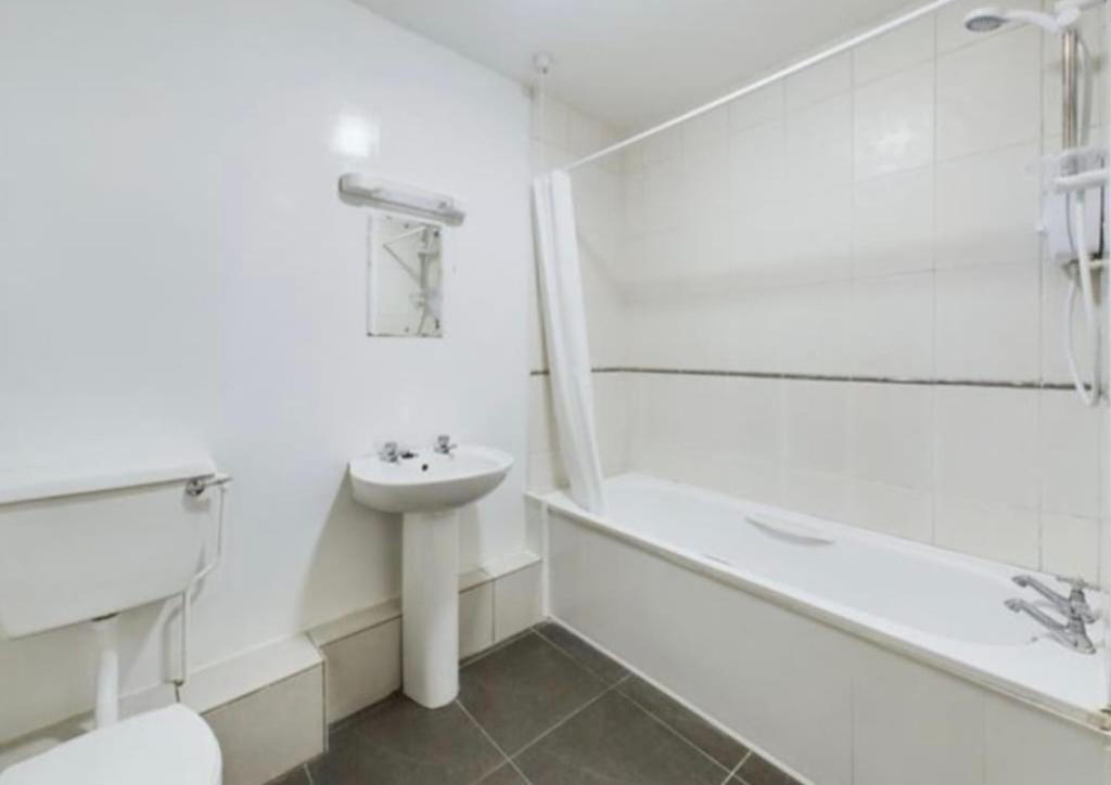 a white bathroom with a sink and a tub and a toilet at holiday in Waterford