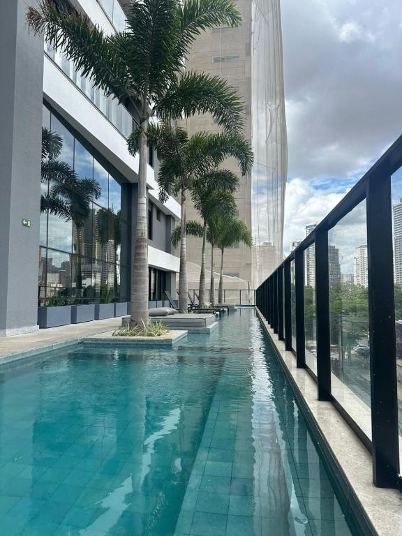 a swimming pool on the roof of a building with palm trees at Studio Premium com lazer completo , ótima localização in Goiânia
