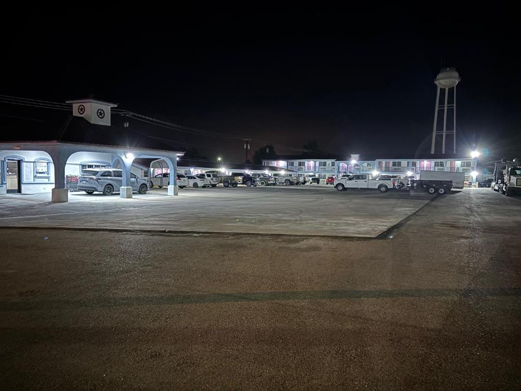 a gas station at night with cars parked in a parking lot at Kermit Inn in Kermit