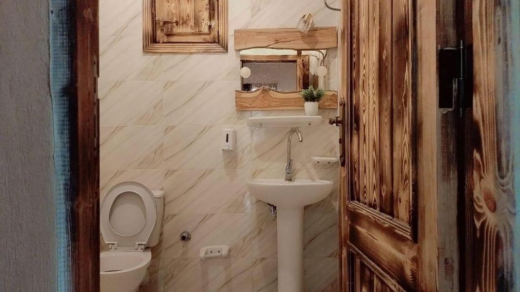 a small bathroom with a toilet and a sink at Shasha Ecolodge in Siwa