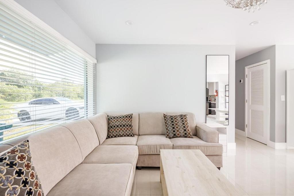 un soggiorno con un divano e un tavolo di 4 BR home with private pool a Fort Lauderdale