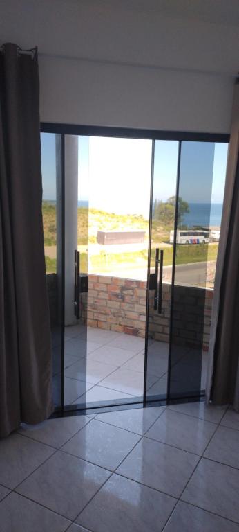 een open glazen deur met uitzicht op de oceaan bij Vista mar 1 in Imbituba