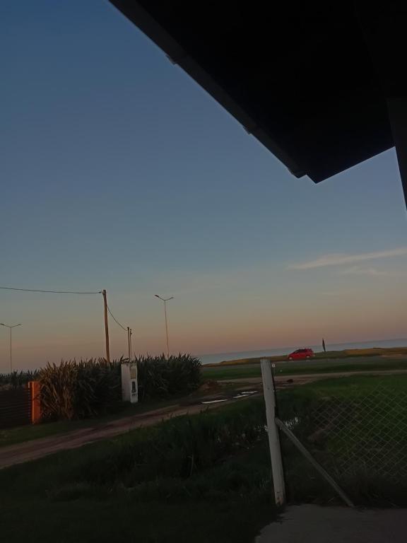 Blick auf eine Straße mit einem Zaun und einem Feld in der Unterkunft Departamento santa elena in Frente Mar