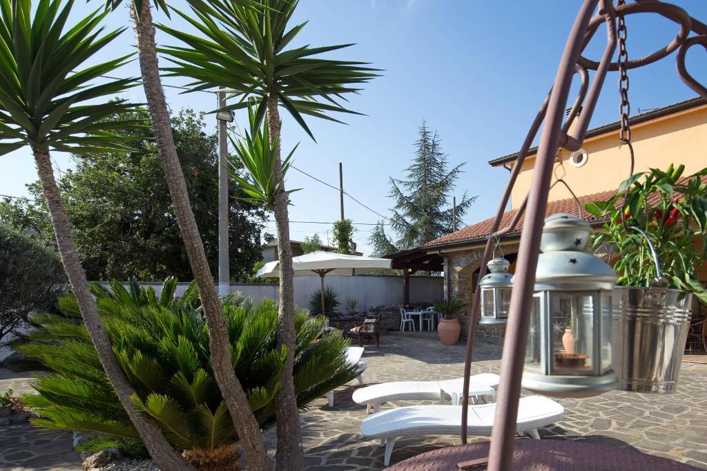 eine Terrasse mit Palmen und einer Laterne in der Unterkunft B&B Fasolino in Castellabate