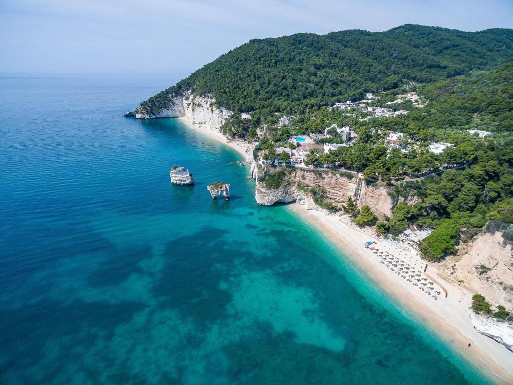 uma vista aérea de uma praia com barcos na água em Baia Delle Zagare - Handwritten Collection em Mattinata