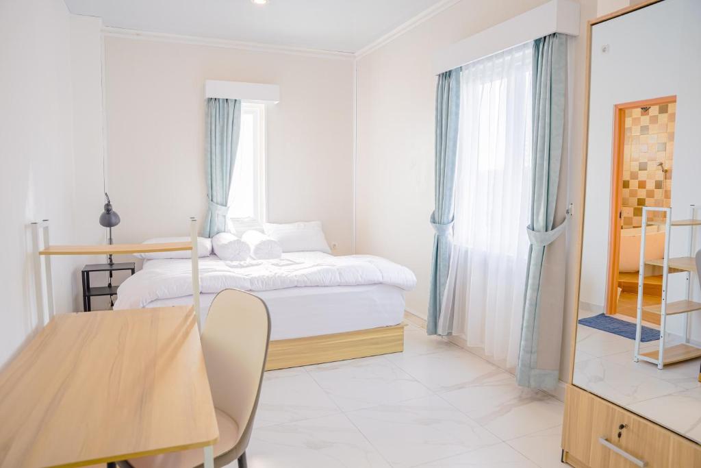 a bedroom with a bed and a desk and a table at Casal Apartment by REJA Essentials in Nusa Dua